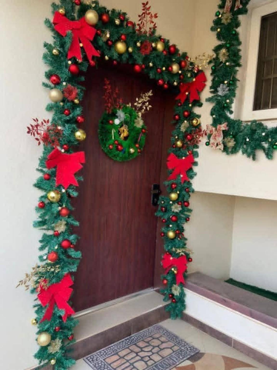 Red and green Christmas garland framing a front door