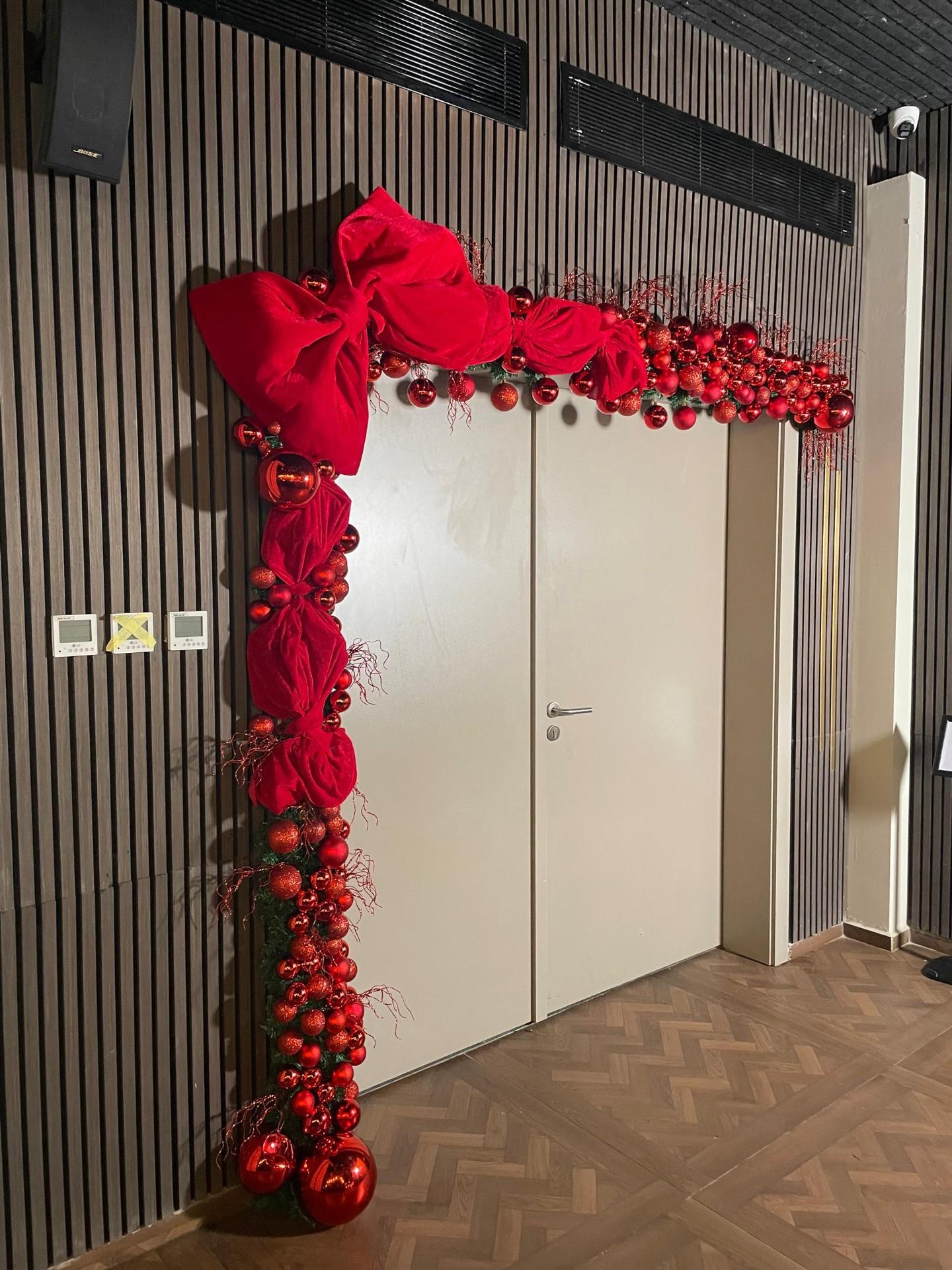 Christmas door decoration with red bows and garland in Abuja Nigeria by FOA_gifts holiday styling