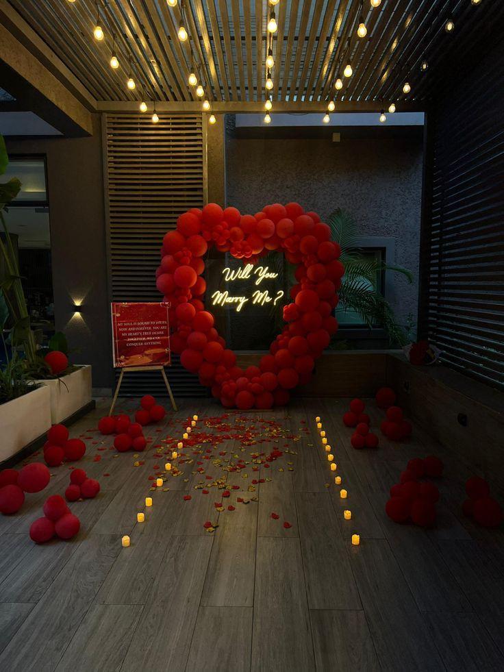 Red heart balloon arch proposal setup with neon Will You Marry Me sign and candles in Abuja Nigeria FOA_gifts